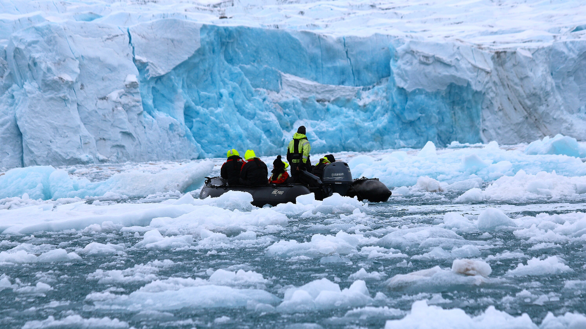 Zodiac exploring beside a glacier in Svalbard